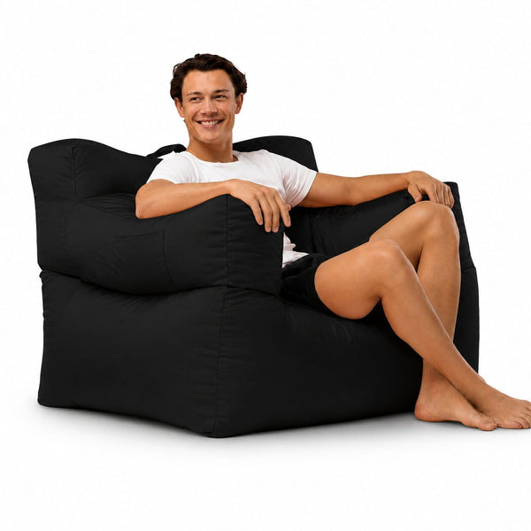 smiling man posing on a black armchair bean bag