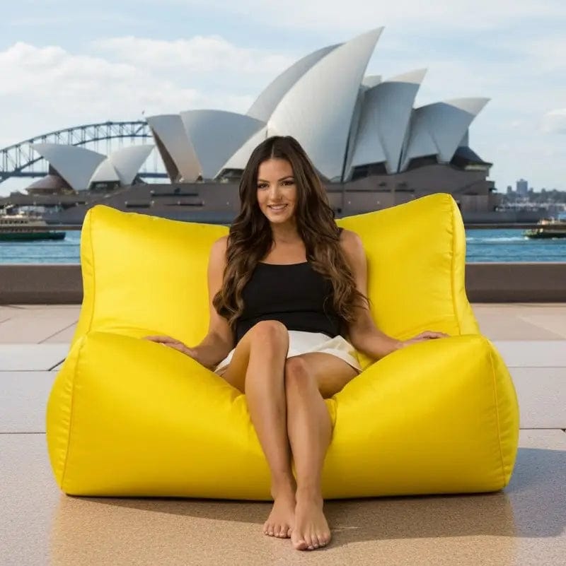 Woman sitting on a yellow bean bag chair with the Sydney Opera House in the background
