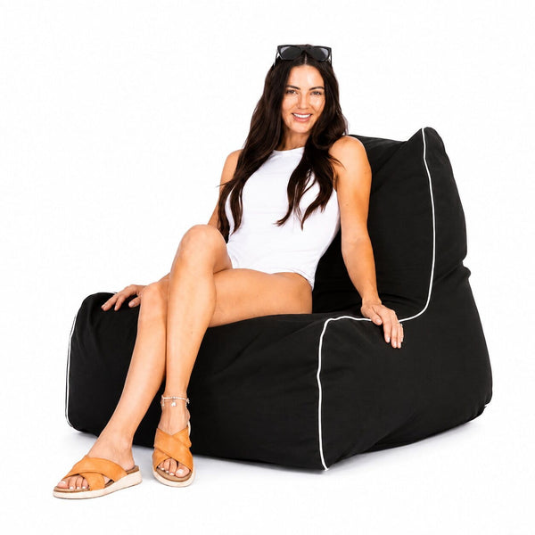 lady in white swimsuit posing on a black copacabana outdoor bean bag chair