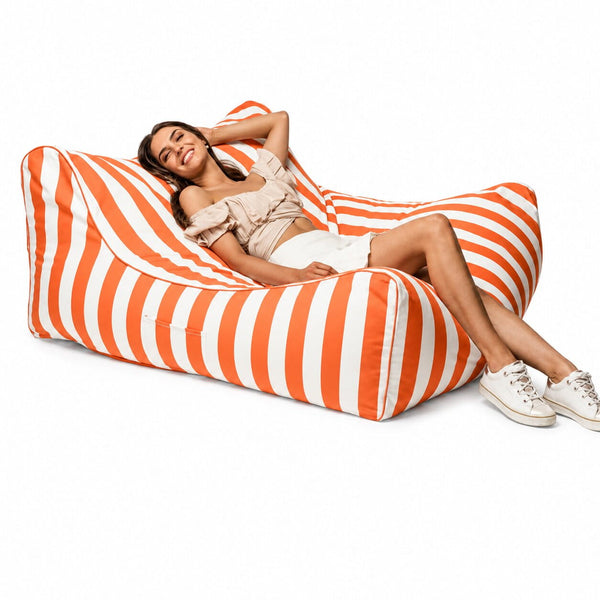 lady posing on an orange stripe costa outdoor bean bag lounger by bean bags r us