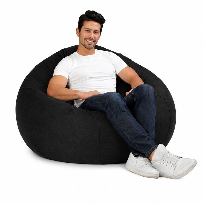 man posing on a huge grey denim bean bag chair