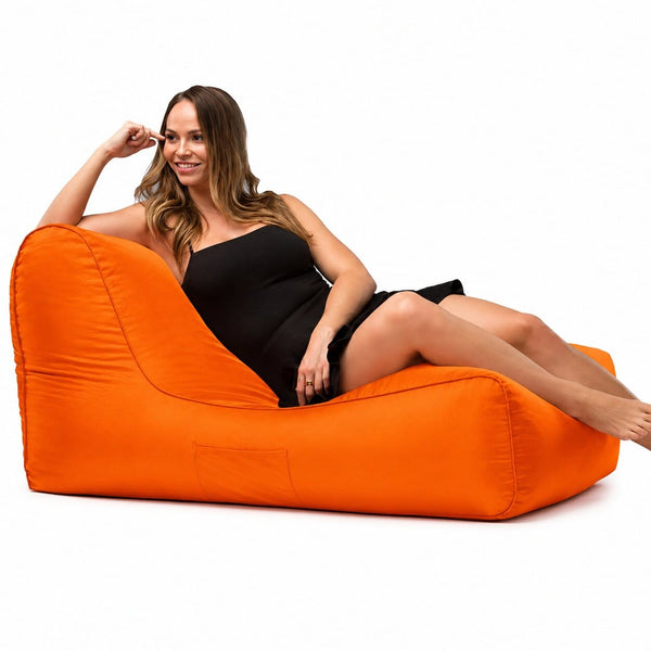 lady posing on a media lounge outdoor bean bag lounger in orange