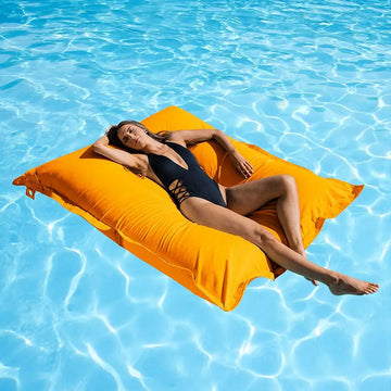 Woman lying on a yellow lounger in a pool
