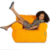 Child sitting on an orange bean bag chair against a white background