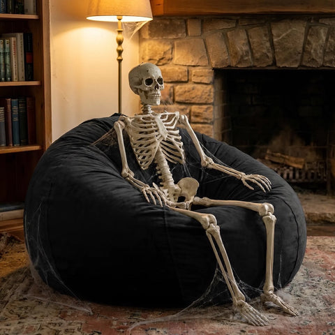 a skeleton sitting on a very old dusty bean bag chair from the 70s
