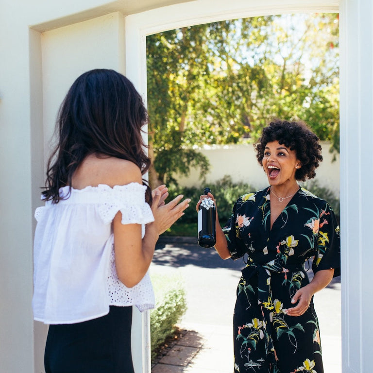 two ladies at front door one with a gift 
