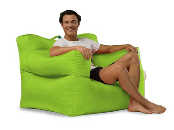 Person sitting on a large green bean bag chair against a white background