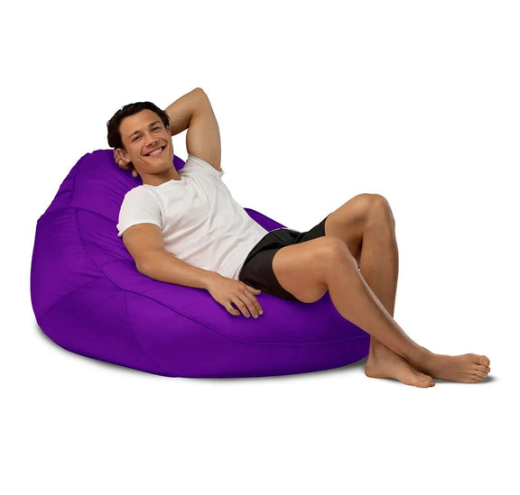 Man relaxing on a purple bean bag chair against a white background