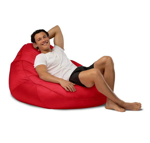 Man relaxing on a red bean bag chair against a white background