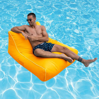 Man lounging on a yellow pool float chair in a pool
