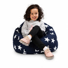 smiling young girl sitting on a blue bean bag chair with white stars — thumbnail 8
