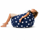 young boy laid back on a blue beanbag with white stars — thumbnail 7