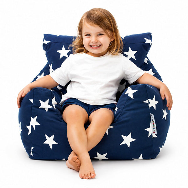 smiling young girl sitting on a blue bean bag chair with white stars — image 3