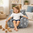 smiling young girl sitting on a grey bean bag chair with silver stars playing with wooden shapes — thumbnail 6
