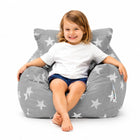 smiling young girl sitting on a grey bean bag chair with silver stars — thumbnail 1