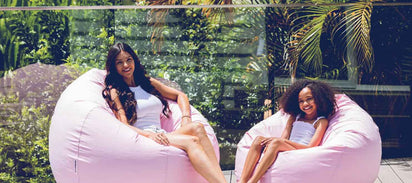 girls sitting on pink outdoor beanbag chairs