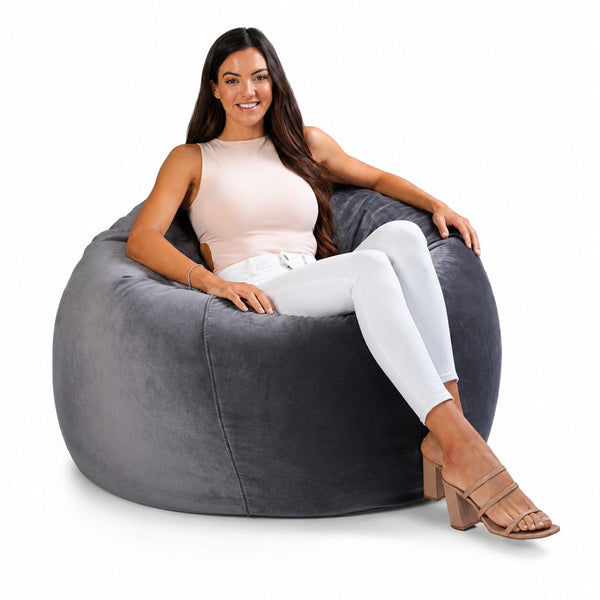 smiling lady posing on a grey velvet bean bag chair — image 10
