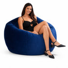 happy lady posing on a blue velvet bean bag chair — thumbnail 5