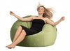 Woman relaxing on a green bean bag chair against a white background