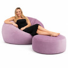lady posing on a pale pink velvet bean bag and ottoman — thumbnail 1