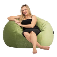 Woman sitting on a green bean bag chair against a white background