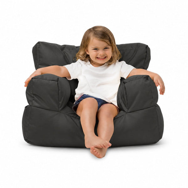 smiling young girl posing on a charcoal kids bean bag chair — image 10