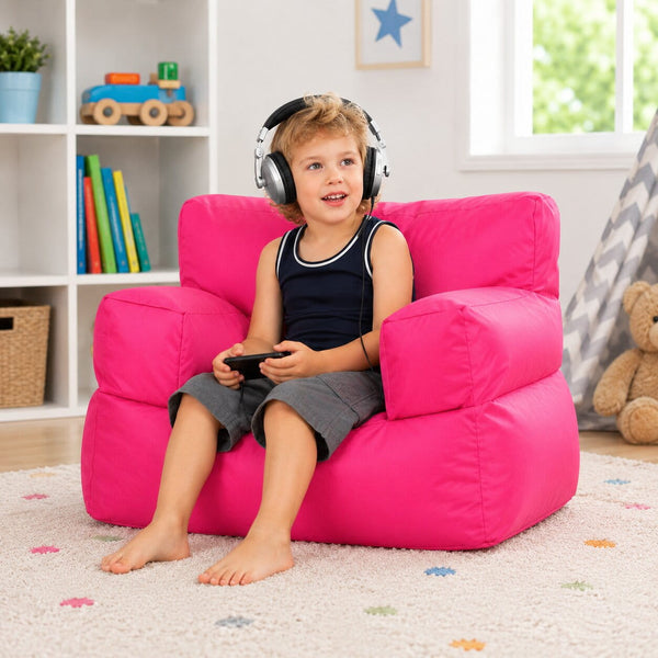 smiling young boy posing on a pink kids bean bag chair in a kids room — image 3