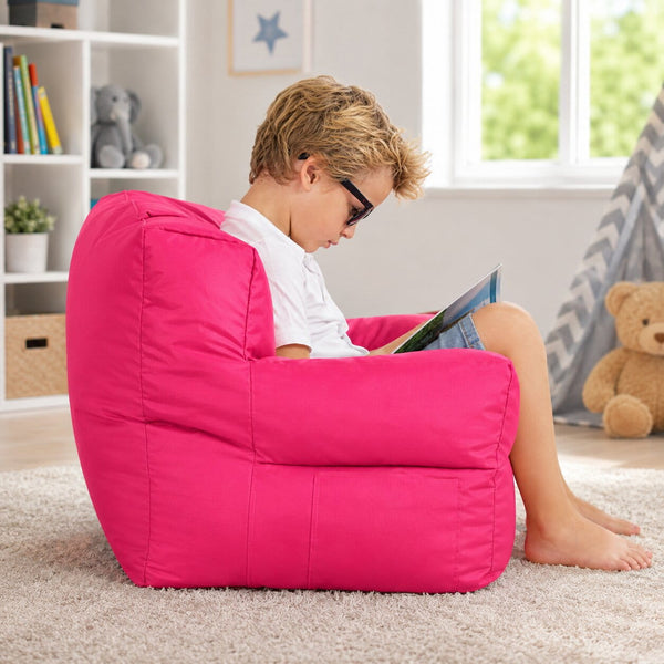 young boy posing on a pink kids bean bag chair in a kids room — image 4