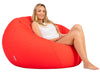 Woman sitting on a large red bean bag chair against a white background