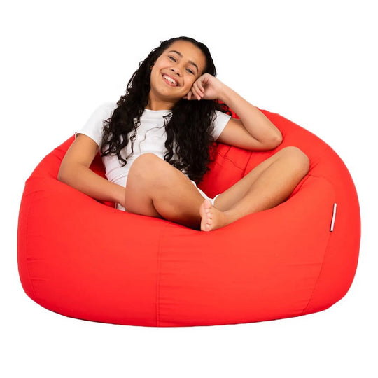 teenage girl sitting on a bright red beanbag chair