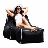 lady posing on a black outdoor bean bag chair wit feet up on an ottoman