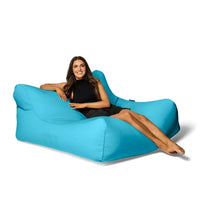 Woman sitting on a large blue bean bag chair against a white background