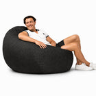 happy man posing on a large charcoal denim bean bag — thumbnail 5