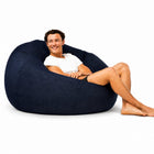 man posing on a large indigo blue denim bean bag — thumbnail 6