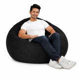 man posing on a huge grey denim bean bag chair