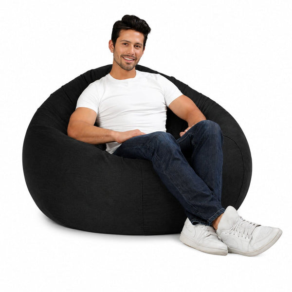 man posing on a huge grey denim bean bag chair — image 7