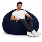 smiling man posing on a huge indigo denim bean bag chair — thumbnail 8