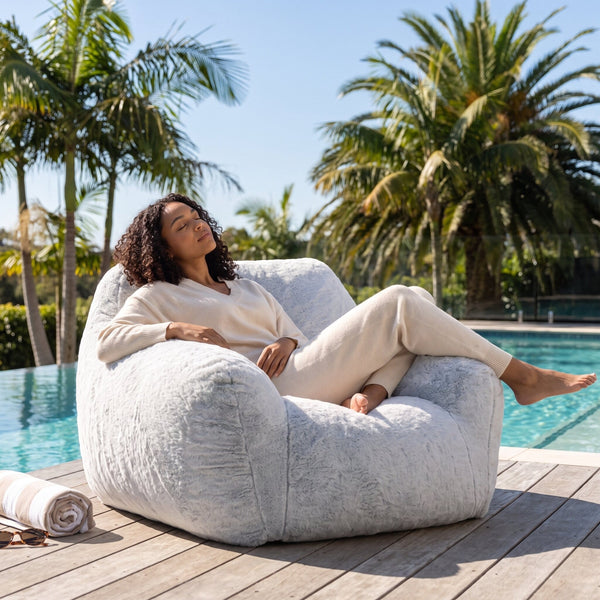 a lady relaxing on a foam filled sensory bean bag chair on a deck — image 3