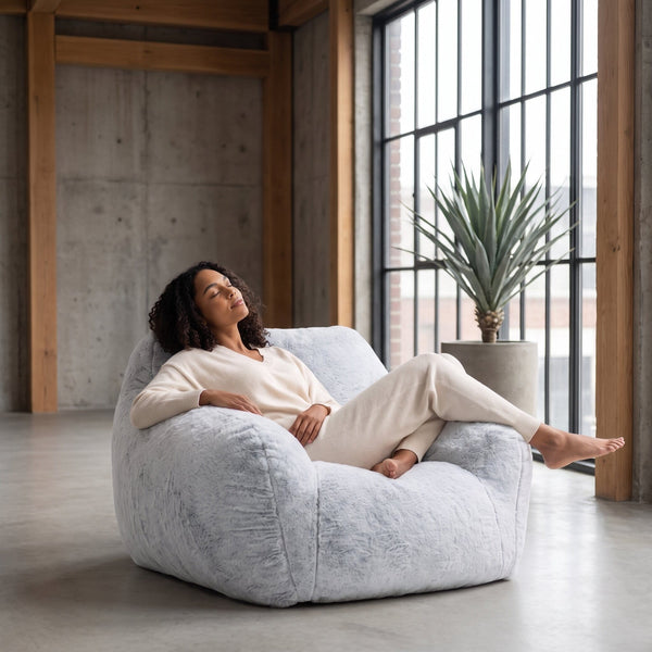 a lady relaxing on a light grey coloured foam filled sensory bean bag chair  — image 4