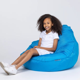 Child sitting on a blue bean bag chair against a white background