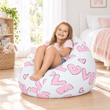 Smiling girl on a white Kids Coco bean bag with pink LOVE and hearts print in a sunny bedroom, Bean Bags R Us