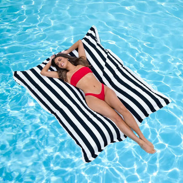 Woman lying on a black & white striped Portsea pool float in a pool