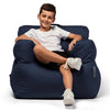 Child sitting on a navy bean bag chair against a white background